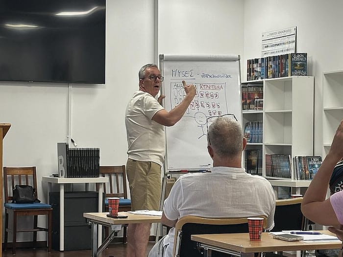 Prednášajúci vysvetľuje tému na flipcharte